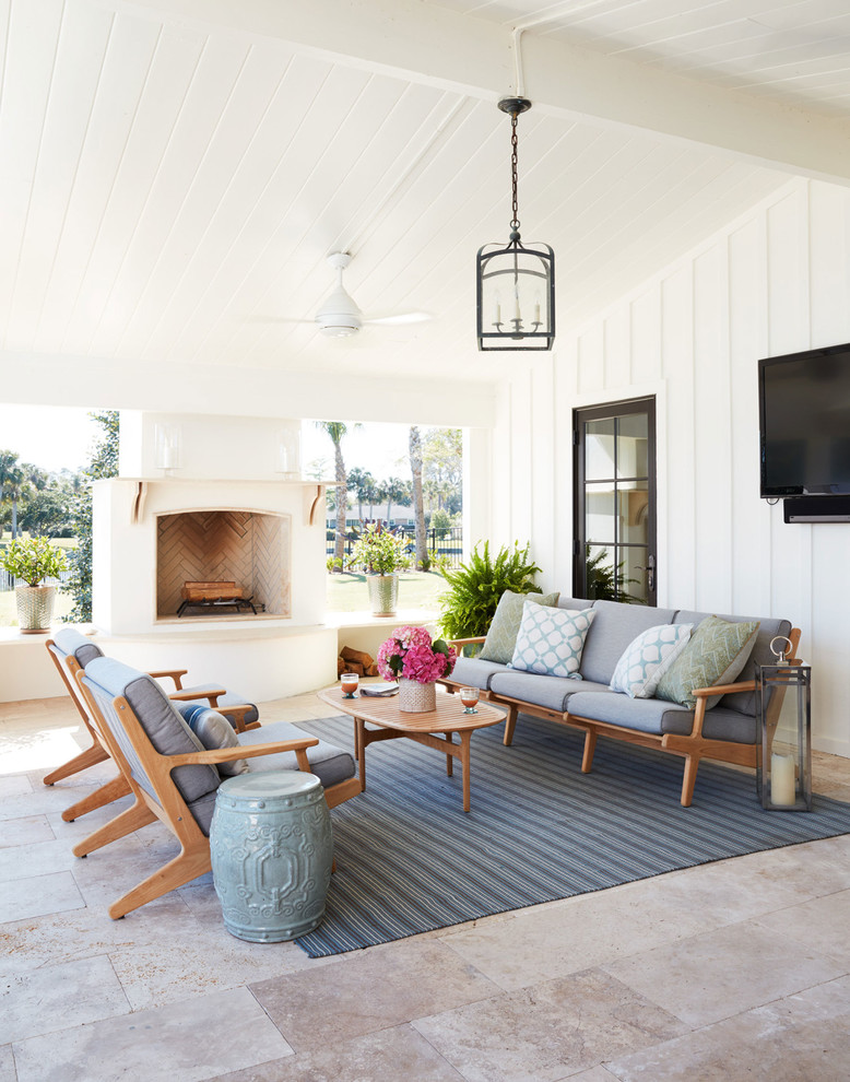 Inspiration for an expansive beach style back patio in Jacksonville with tiled flooring, a roof extension and a fireplace.