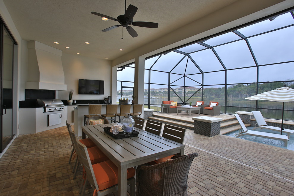 Exemple d'une terrasse arrière éclectique avec une cuisine d'été et une extension de toiture.