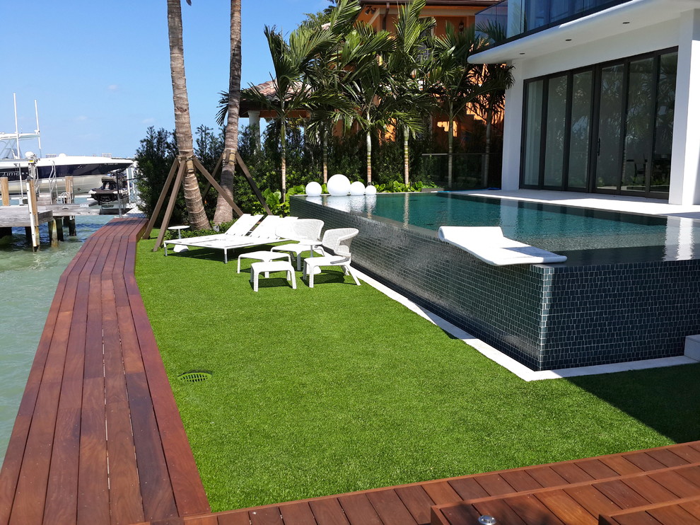 This is an example of a large traditional back patio in Miami with decking and no cover.