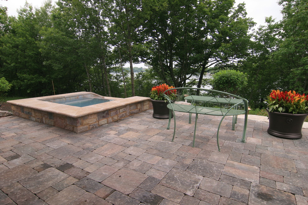 Inspiration pour une terrasse arrière design de taille moyenne avec un point d'eau et des pavés en béton.