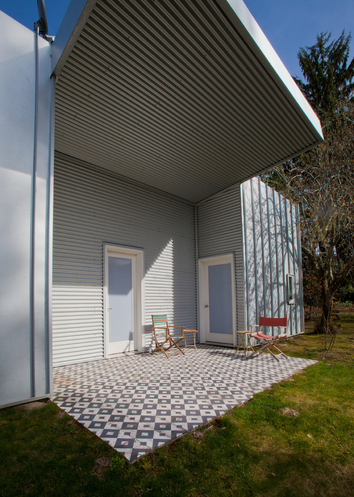 This is an example of a modern patio in Seattle with a roof extension.