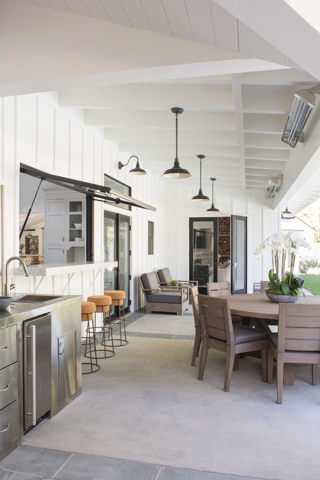Inspiration for a large farmhouse backyard concrete paver patio remodel in Los Angeles with a roof extension