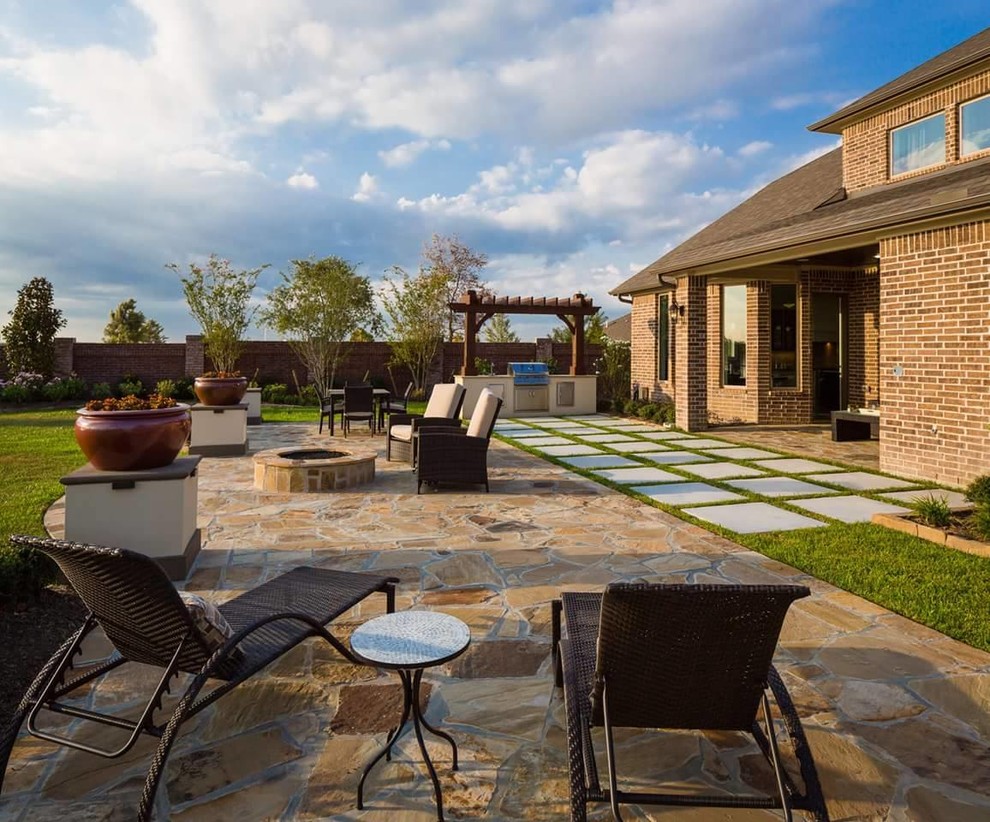 Inspiration for a large classic back patio in Houston with a fire feature, natural stone paving and a pergola.