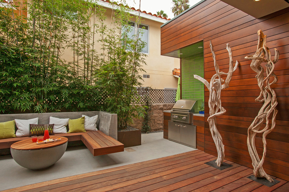 Esempio di un grande patio o portico moderno dietro casa con un focolare, pedane e un tetto a sbalzo