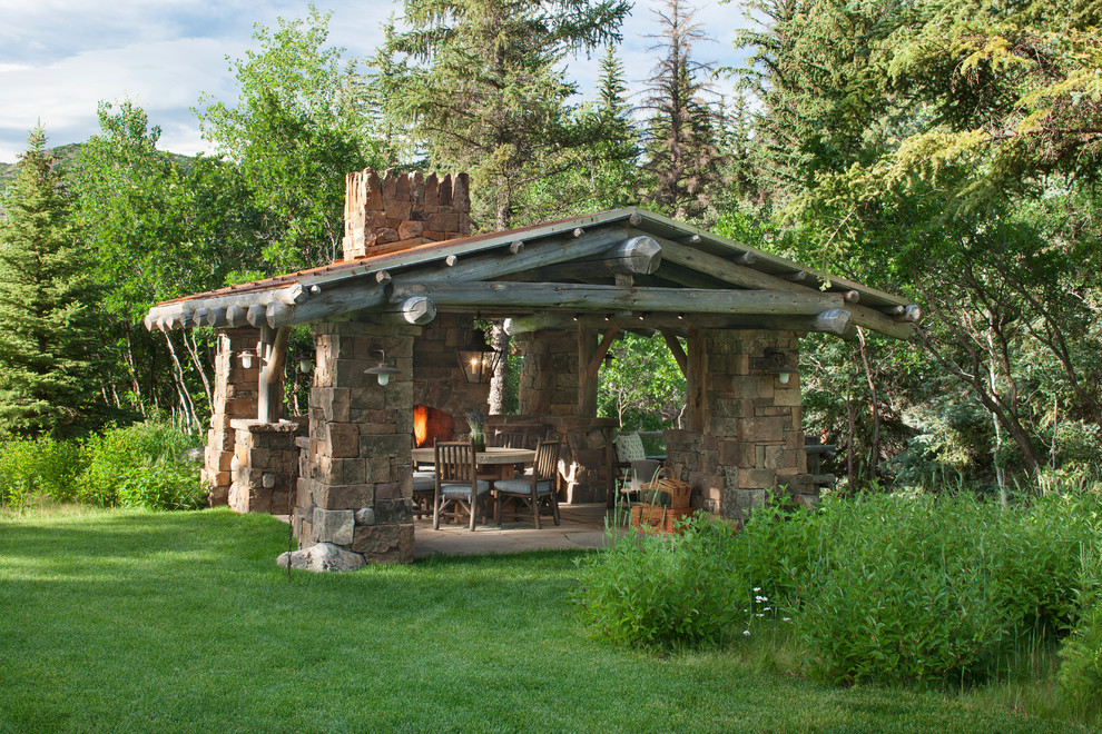 Esempio di un patio o portico rustico di medie dimensioni e dietro casa con un focolare, pavimentazioni in pietra naturale e un gazebo o capanno