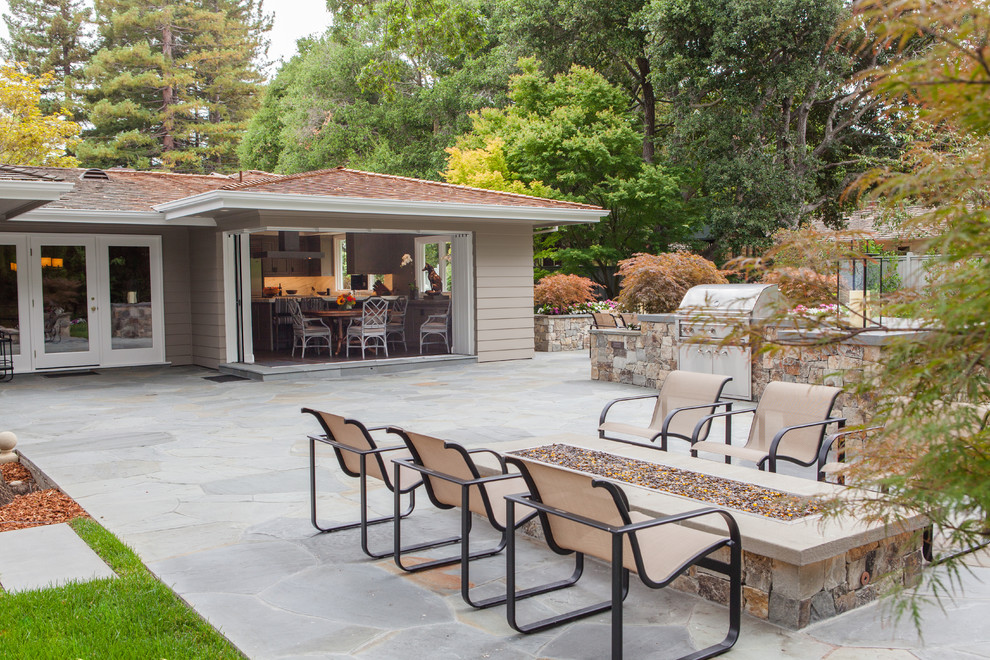 Example of a mid-sized transitional backyard stone patio design in San Francisco with a fire pit and no cover