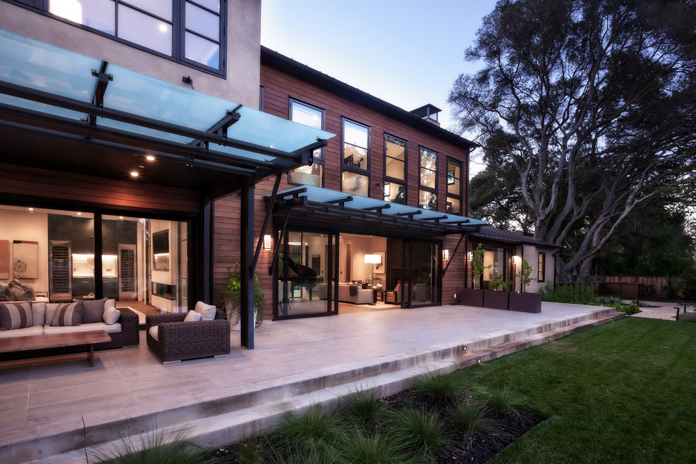 Идея дизайна: большой двор на заднем дворе в стиле модернизм с покрытием из плитки и навесом