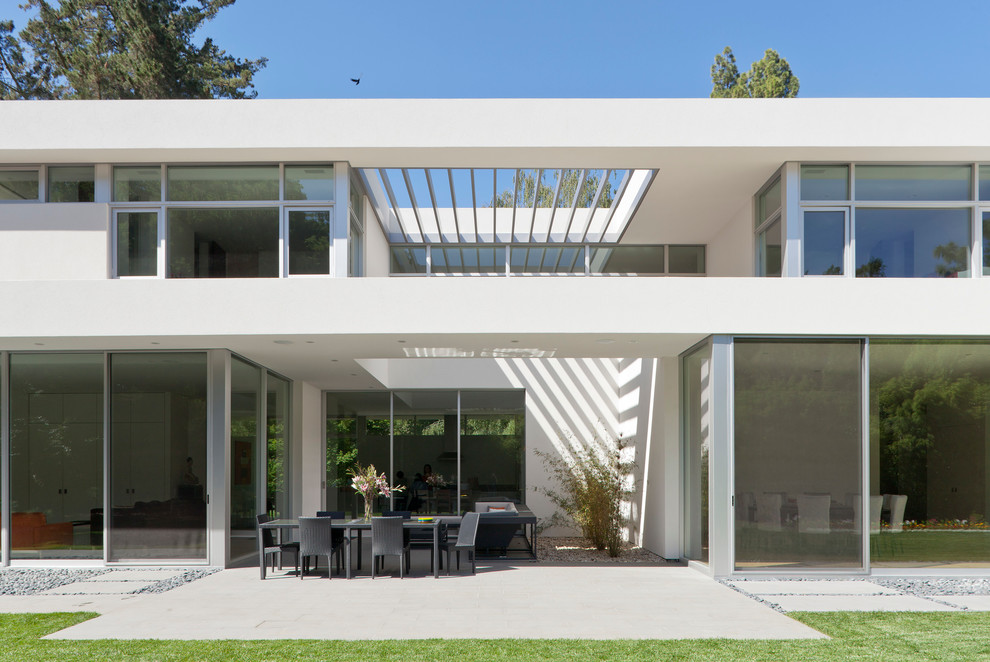 Immagine di un grande patio o portico minimalista dietro casa con una pergola e pavimentazioni in cemento