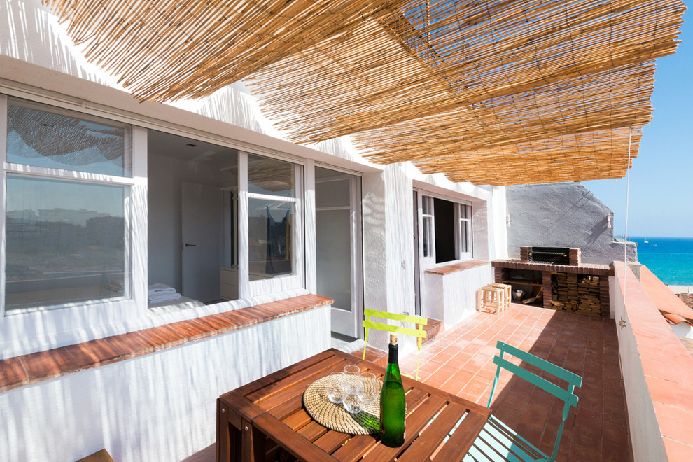 Cette image montre une terrasse arrière méditerranéenne de taille moyenne avec une cuisine d'été et un auvent.