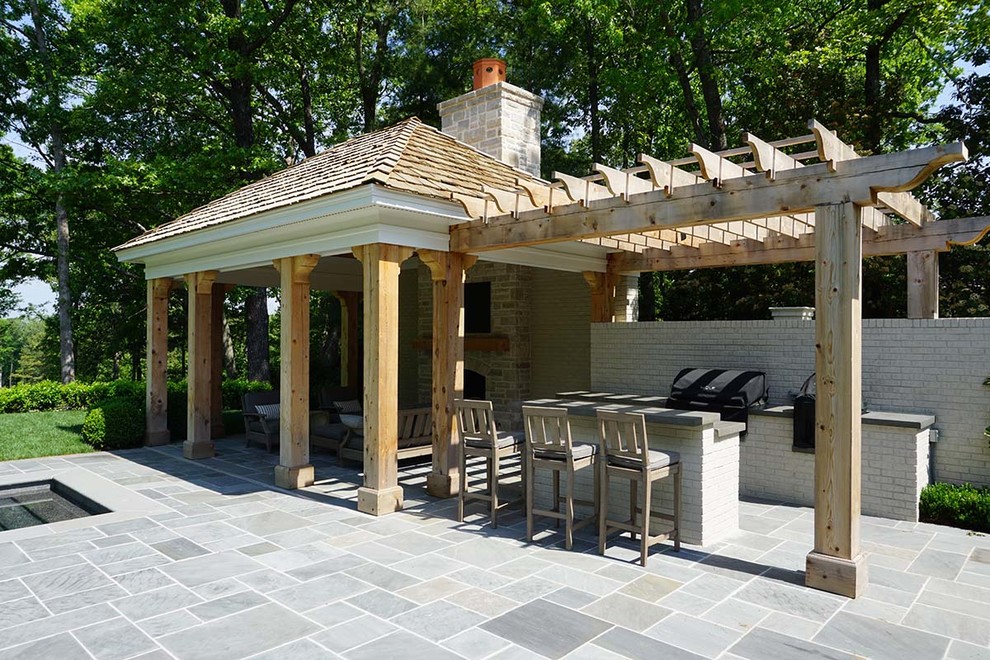 Idee per un grande patio o portico tradizionale dietro casa con un caminetto, piastrelle e un gazebo o capanno