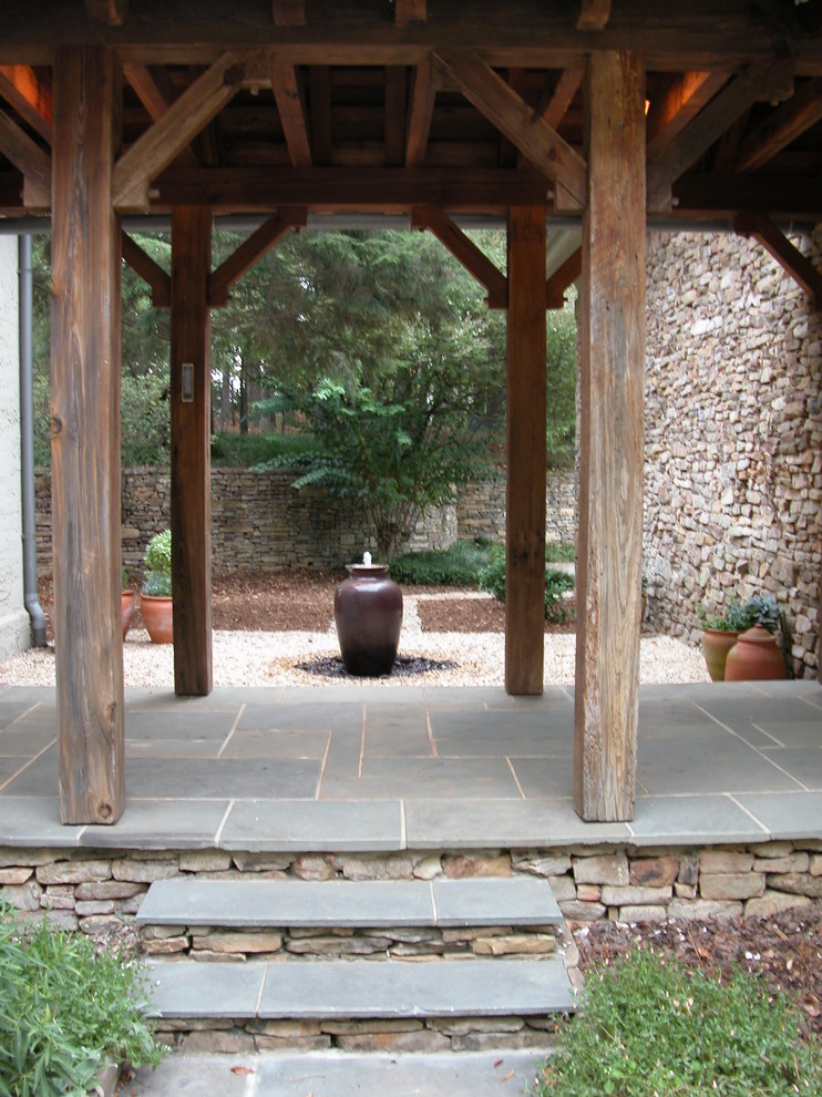 Modelo de patio rural grande sin cubierta en patio trasero con fuente y adoquines de hormigón