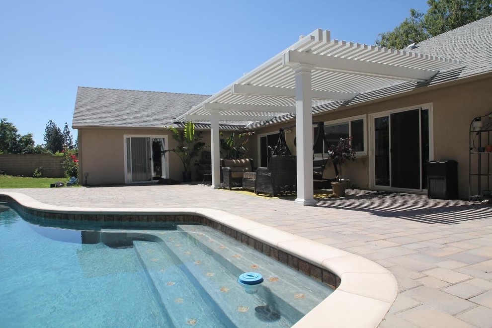 Foto di un patio o portico minimal di medie dimensioni e dietro casa con una pergola e pavimentazioni in mattoni