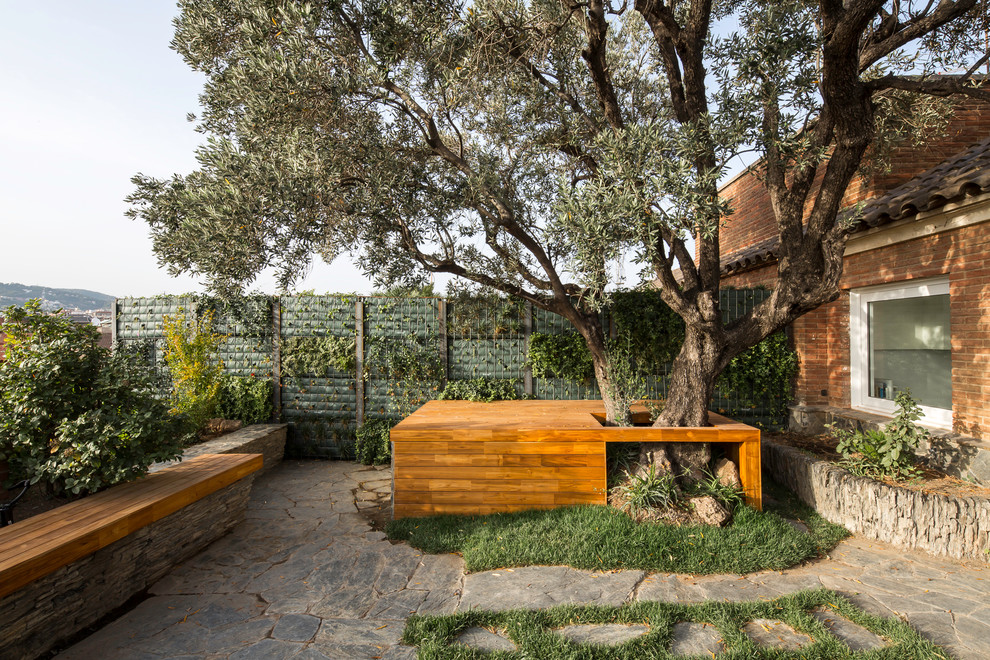 Mittelgroßer Moderner Patio hinter dem Haus mit Pflanzwand und Natursteinplatten in Barcelona