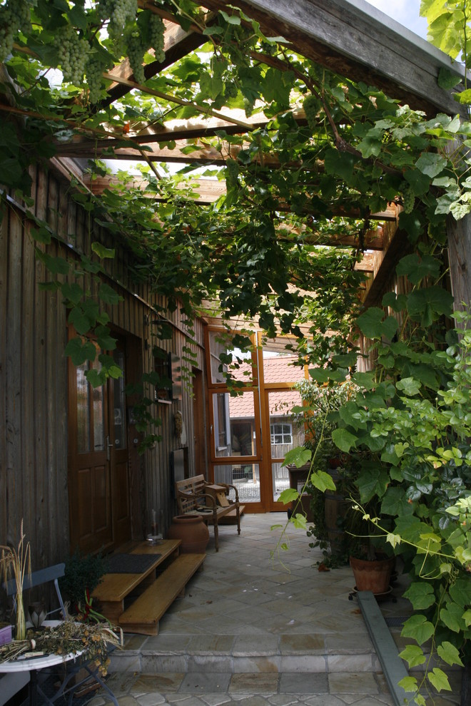 Immagine di un patio o portico tradizionale di medie dimensioni e nel cortile laterale con pavimentazioni in pietra naturale