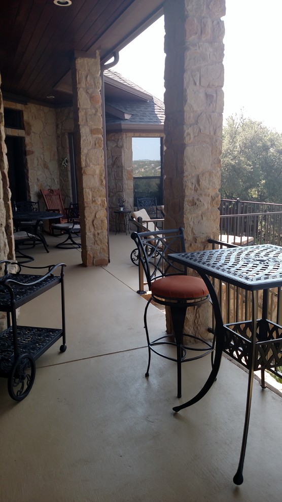 Photo of a medium sized rustic back patio in Austin with an outdoor kitchen, concrete slabs and a roof extension.