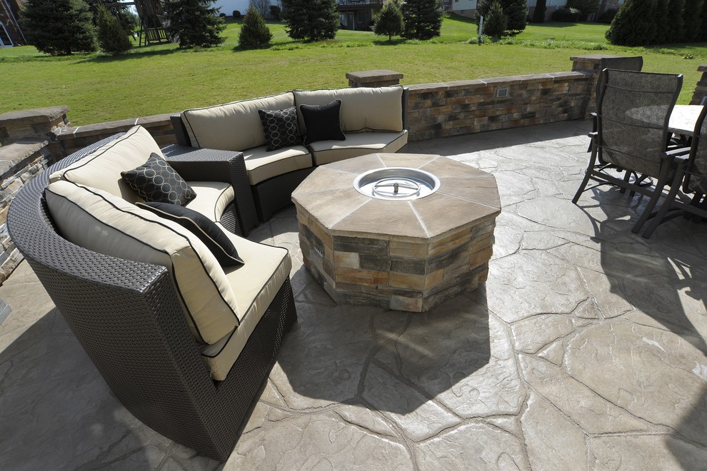 Example of a trendy backyard stamped concrete patio design with a fire pit