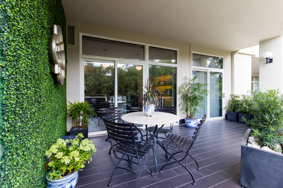 Inspiration pour une terrasse arrière minimaliste avec du carrelage et une extension de toiture.