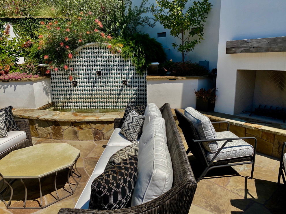Esempio di un grande patio o portico minimalista in cortile con un giardino in vaso e pavimentazioni in pietra naturale