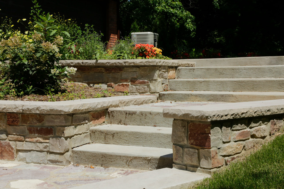 Aménagement d'une terrasse latérale contemporaine avec des pavés en pierre naturelle.