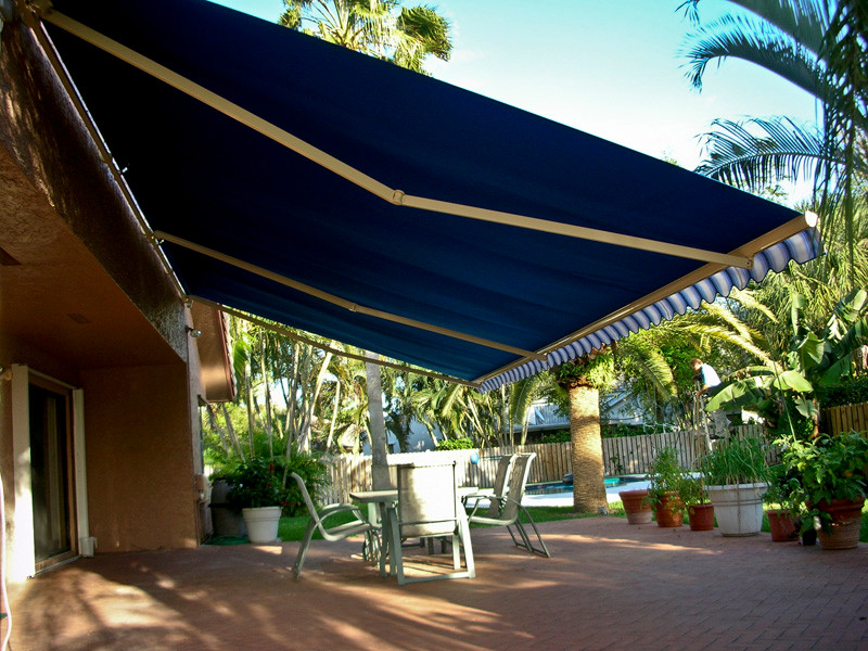 Mid-sized elegant backyard brick patio photo in Orange County with an awning