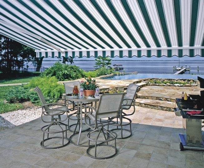 Photo of a large classic back patio in Orange County with an awning and tiled flooring.
