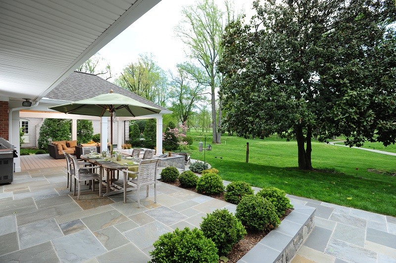 This is an example of a medium sized contemporary back patio in DC Metro with stamped concrete and a roof extension.