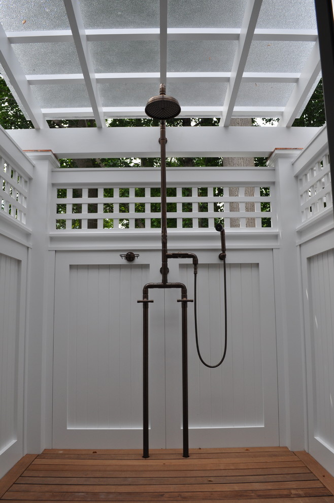 Ejemplo de patio clásico de tamaño medio en patio lateral con ducha exterior, entablado y pérgola