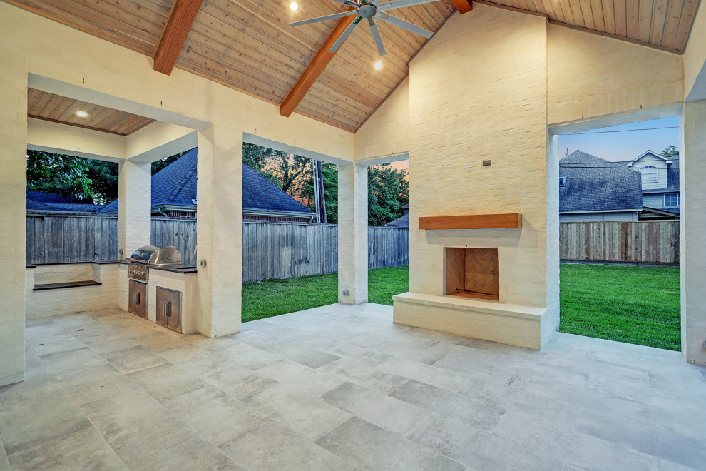 Inspiration for an expansive classic back patio in Houston with a fireplace, tiled flooring and a roof extension.