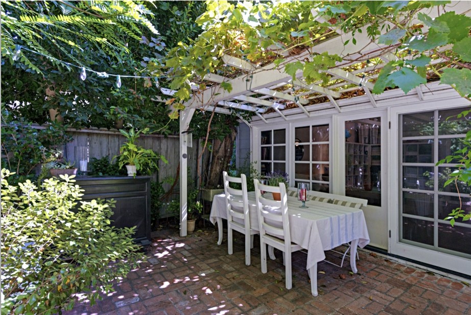 Immagine di un grande patio o portico classico dietro casa con un giardino in vaso, pavimentazioni in mattoni e una pergola