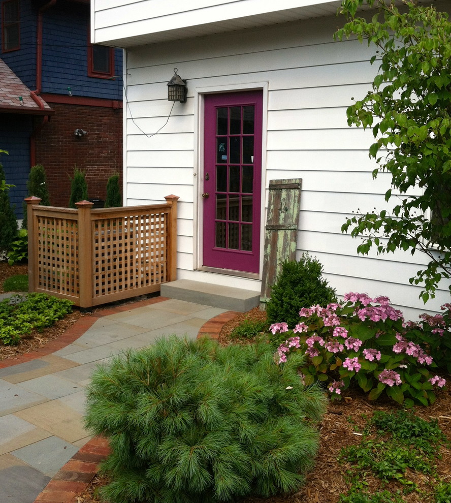 Foto di un patio o portico stile shabby dietro casa e di medie dimensioni con pavimentazioni in pietra naturale, un focolare e un tetto a sbalzo