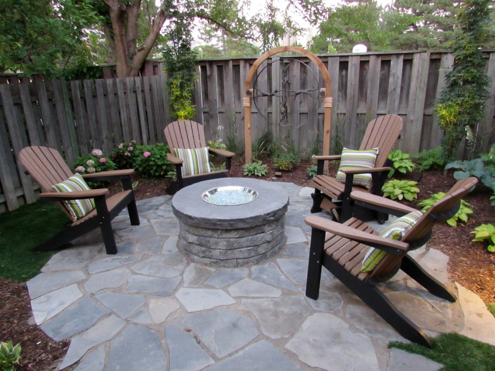 Design ideas for a small traditional back patio in Toronto with a fire feature, natural stone paving and no cover.