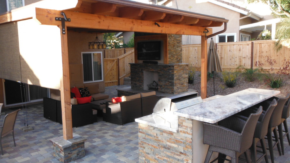 Idee per un patio o portico tradizionale di medie dimensioni e dietro casa con pavimentazioni in cemento e un tetto a sbalzo