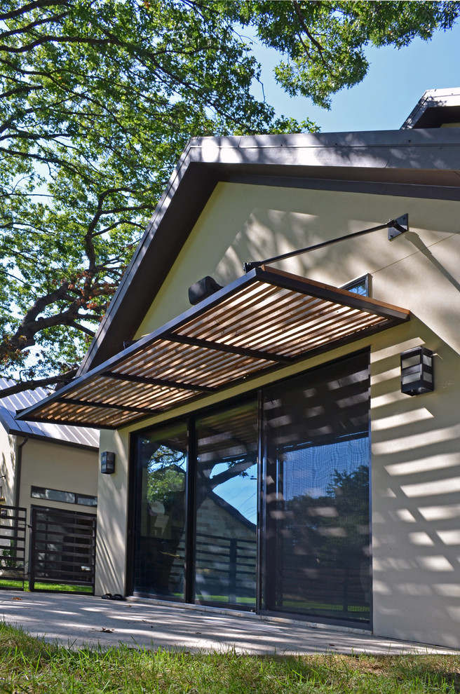 Inspiration pour une petite terrasse arrière minimaliste avec une dalle de béton et un auvent.