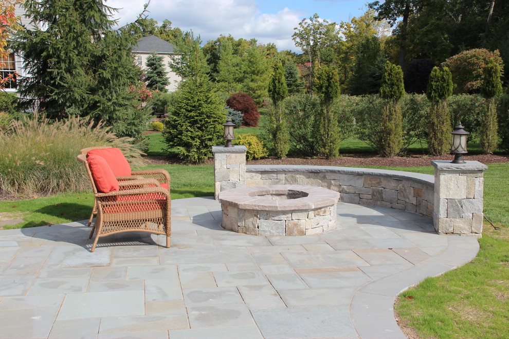 Inspiration for a large timeless backyard tile patio remodel in New York with a fire pit and no cover