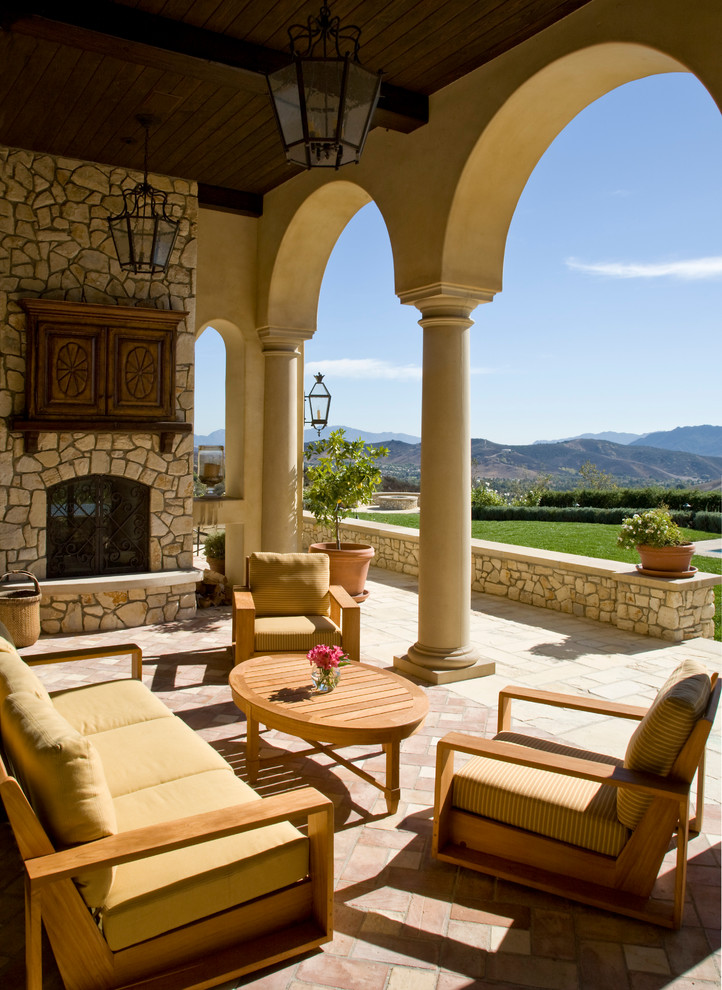 Example of a tuscan patio design in Los Angeles with a fire pit
