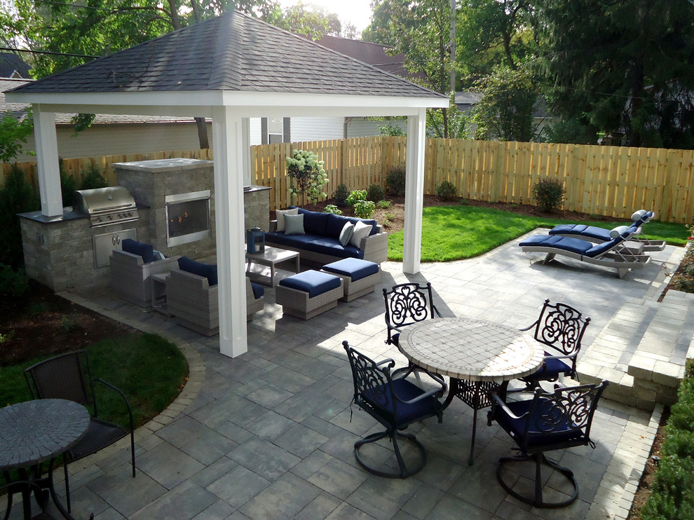 Example of a mid-sized trendy backyard brick patio design in Detroit with a fire pit and a gazebo