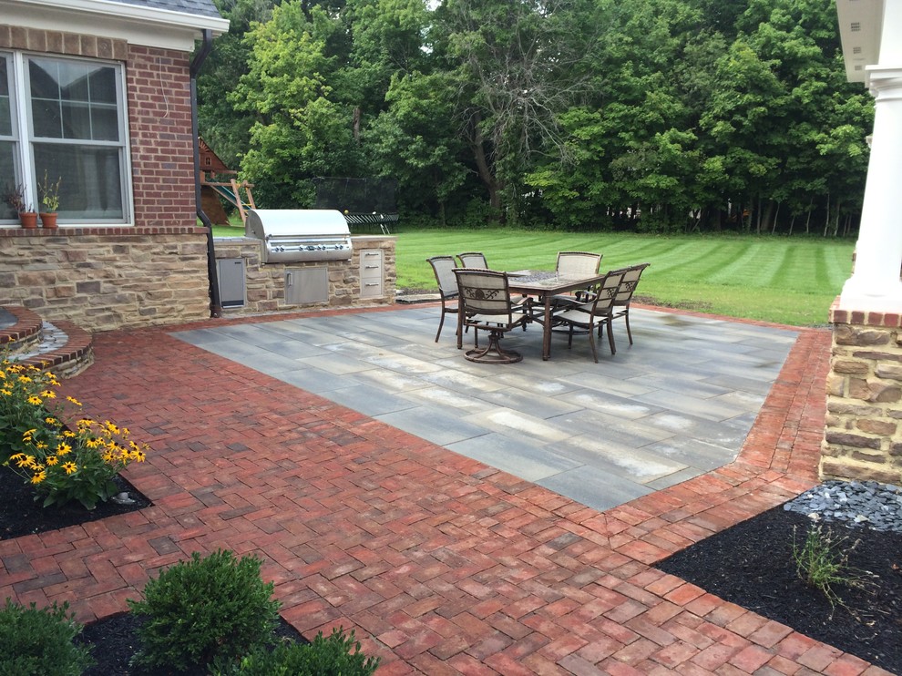 This is an example of a large rustic back patio in Columbus with a fire feature, concrete paving and a gazebo.