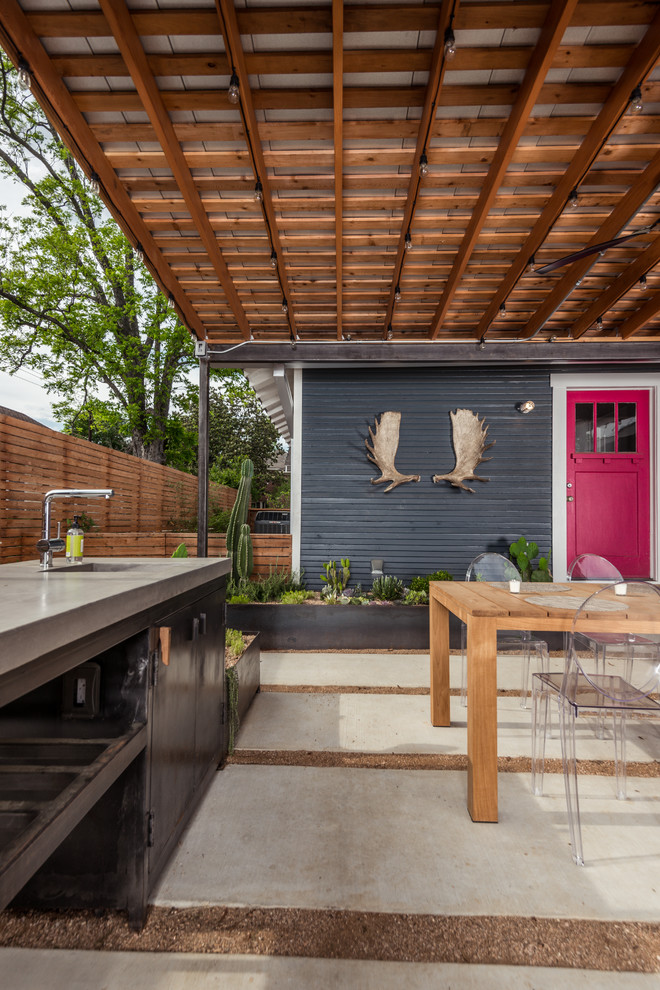 Diseño de patio actual en patio trasero con cocina exterior y adoquines de hormigón