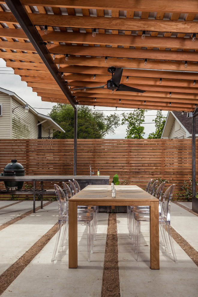 Überdachter Moderner Patio hinter dem Haus mit Betonboden und Grillplatz in Houston