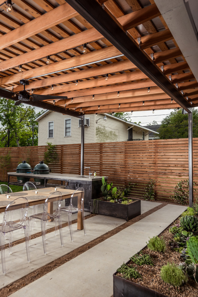 На фото: двор на заднем дворе в современном стиле с летней кухней и мощением тротуарной плиткой