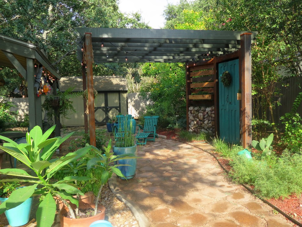 Idee per un patio o portico boho chic di medie dimensioni e dietro casa con un giardino in vaso, pavimentazioni in cemento e una pergola