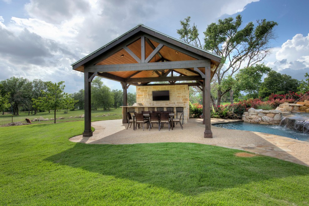 Example of a large classic backyard concrete paver patio kitchen design in Austin with a gazebo
