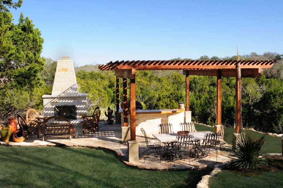 Example of a mid-sized classic backyard concrete paver patio kitchen design in Austin with a pergola