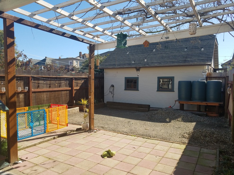 Foto di un piccolo patio o portico shabby-chic style dietro casa con pavimentazioni in cemento e un parasole