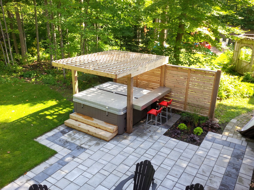Ispirazione per un patio o portico minimalista di medie dimensioni e dietro casa con piastrelle e una pergola