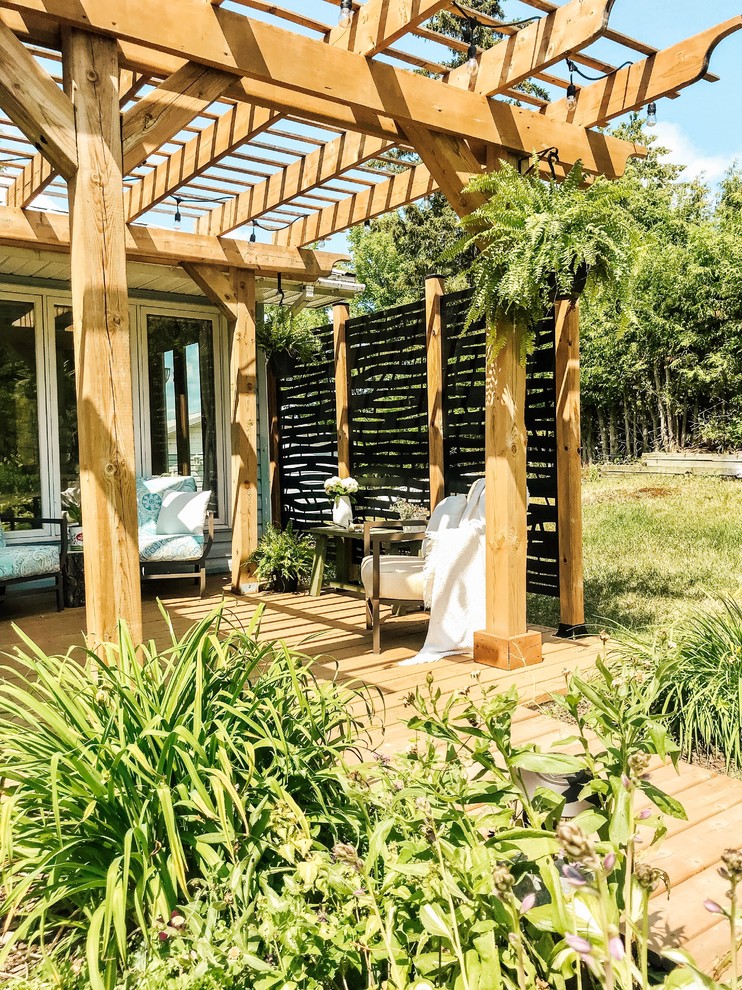 Medium sized rustic back patio in Toronto with decking and a pergola.