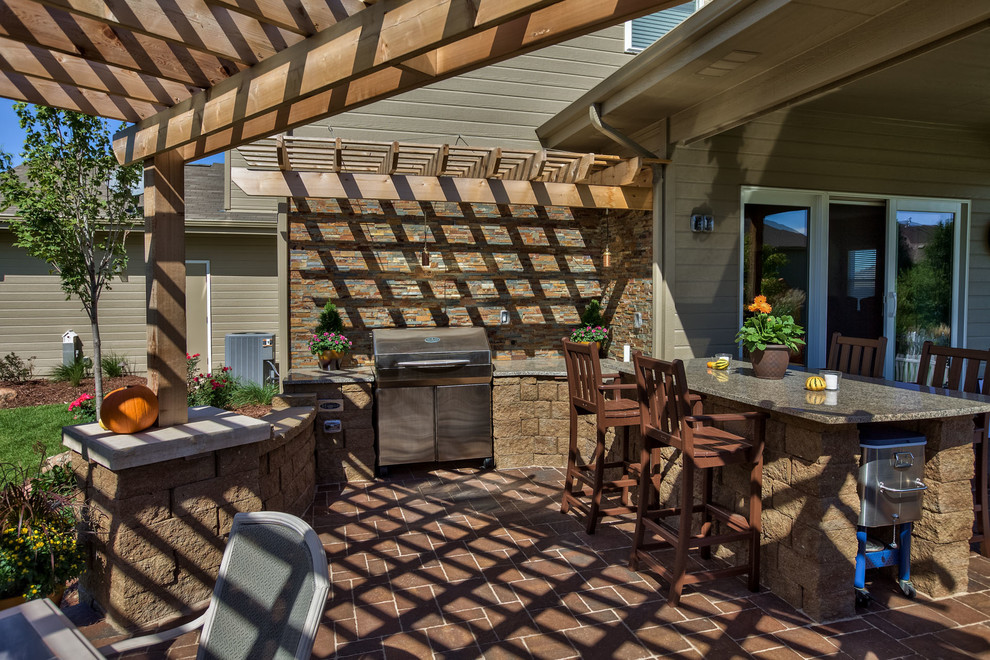 Patio kitchen - mid-sized traditional backyard concrete paver patio kitchen idea in Omaha with a pergola