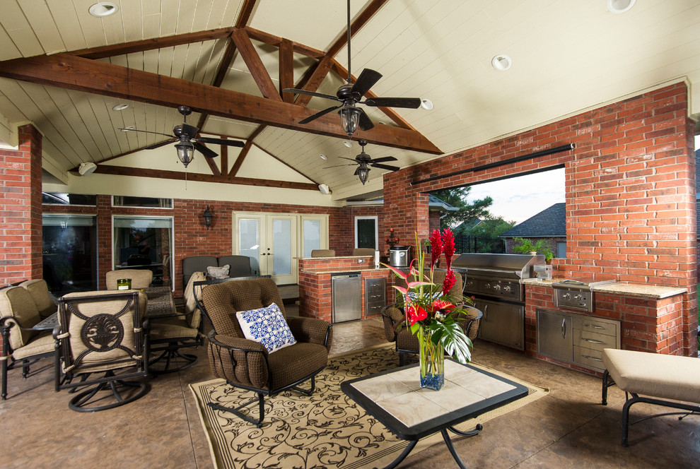 Idée de décoration pour une grande terrasse arrière chalet avec une cuisine d'été, une dalle de béton et une extension de toiture.