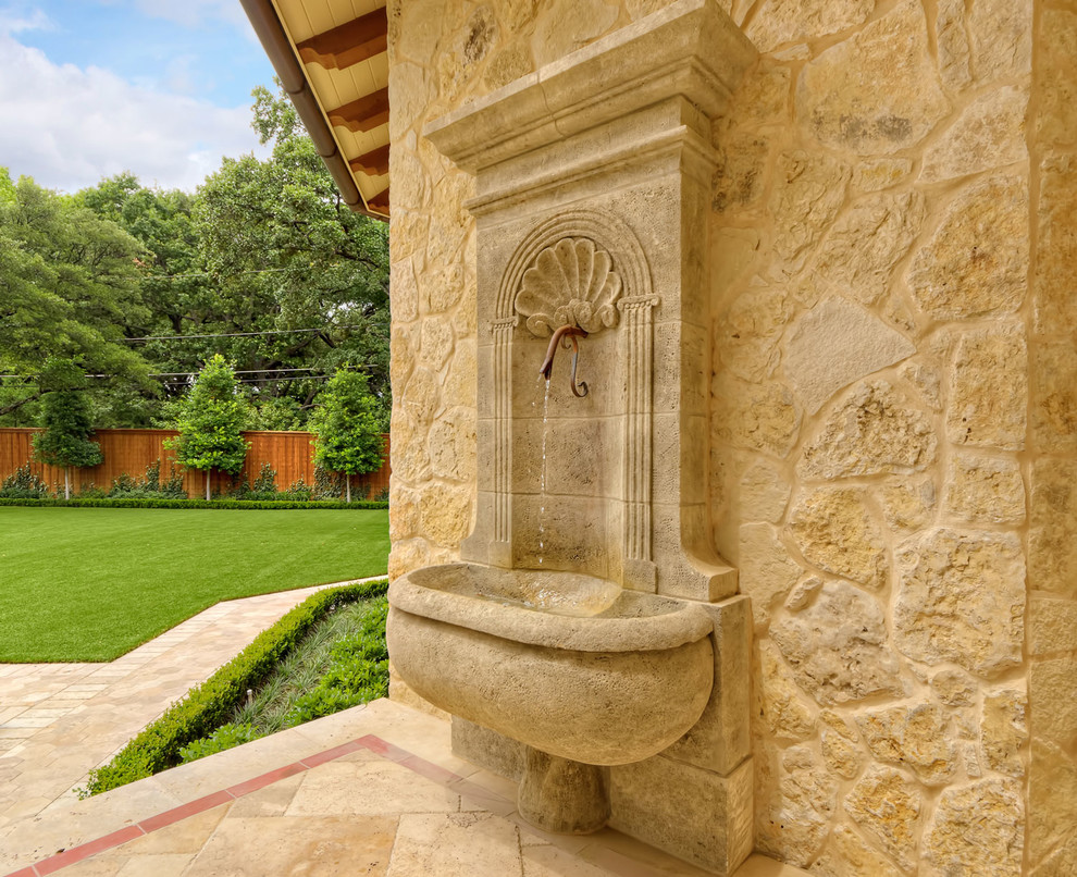 Immagine di un patio o portico mediterraneo di medie dimensioni e dietro casa con fontane, piastrelle e nessuna copertura