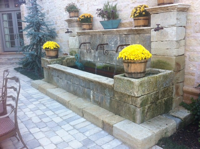 Modelo de patio mediterráneo de tamaño medio sin cubierta en patio trasero con fuente y adoquines de hormigón